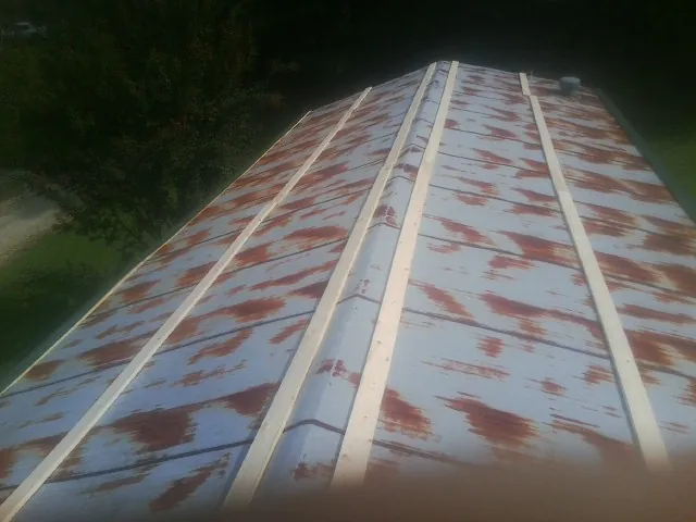 Rusted metal roof panels with new wood purlins before replacement — Storm Damage Roof Repair in Canton by Roofing Brothers